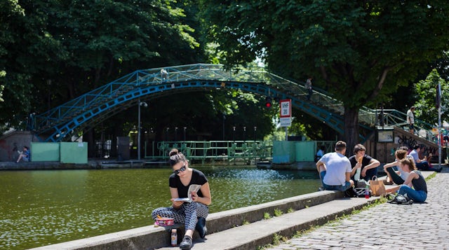 People sitting on the banks of a canal in Paris