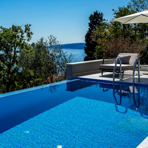 Float in the panoramic infinity pool on a sunny day