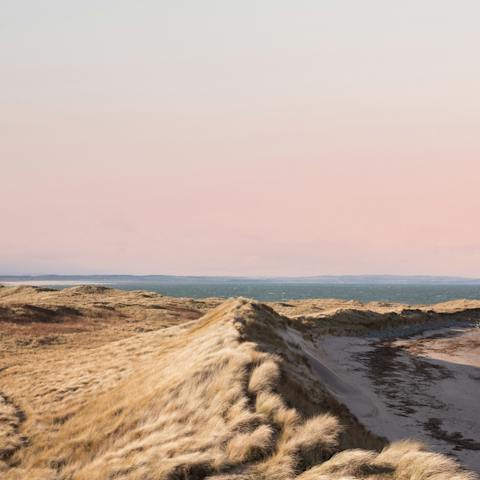 Enjoy sunset strolls along Beadnell Bay Beach, a short walk away