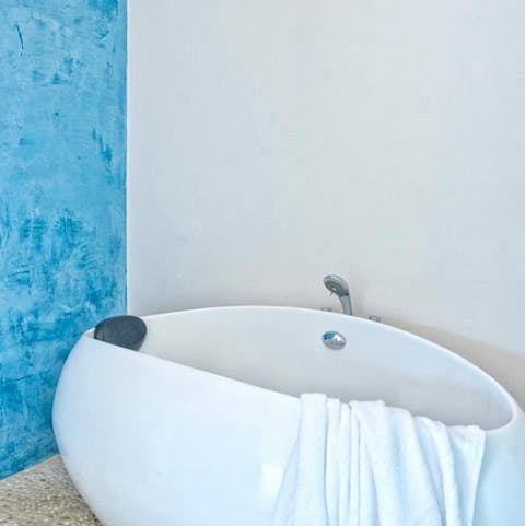 Treat yourself to an restorative soak in the elegant egg-shell bathtub