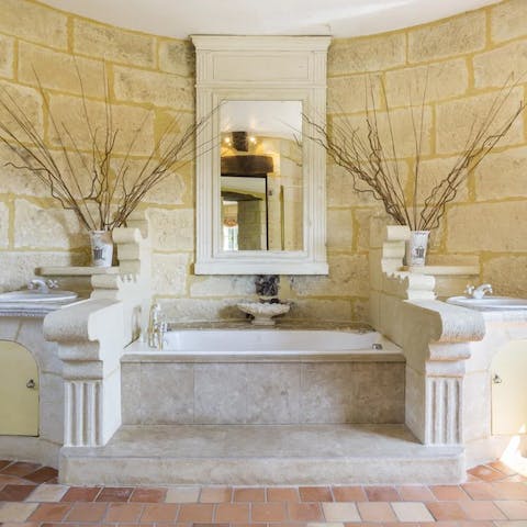 Treat yourself to a leisurely soak in the impressive stone bathroom