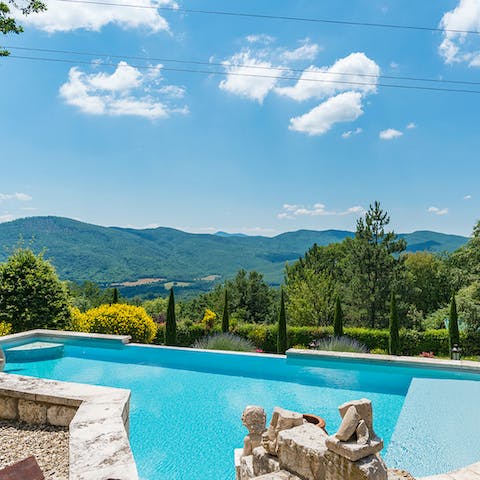 Gaze at rolling Tuscan countryside as you float in the pool