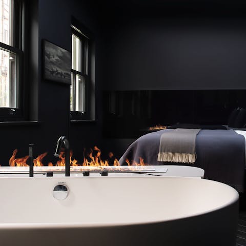 Unwind in the tub with a cocktail in the glow of the fire