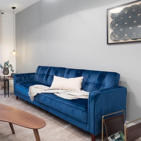 Take a moment for yourself and relax under a throw on the royal blue velvet sofa