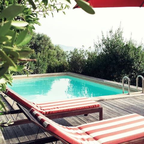 Catch some rays on one of the stripy loungers by the swimming pool