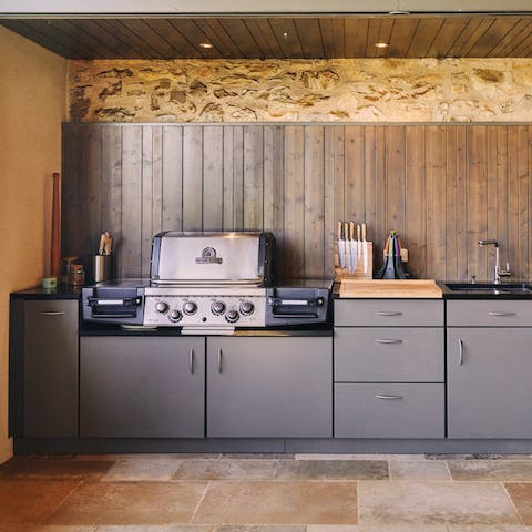 Dine alfresco in the summer at one of the two fully-equipped barbecues in the outdoor kitchen