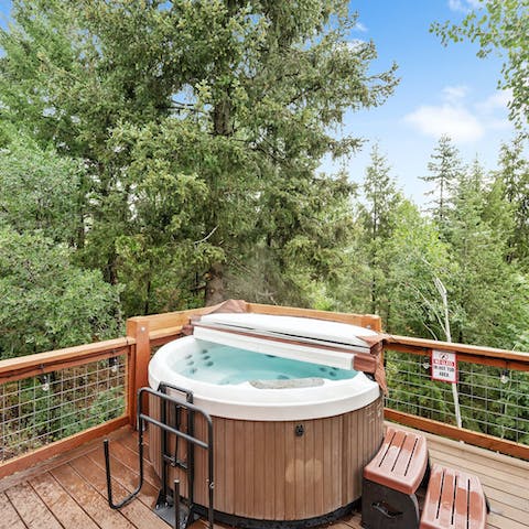 Soak in the hot tub surrounded by the pine trees