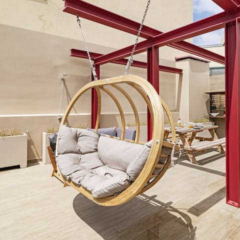 Drift with the gentle breeze in the hanging chair on the communal roof terrace
