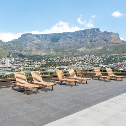 Laze on sun loungers as you look up to Table Mountain