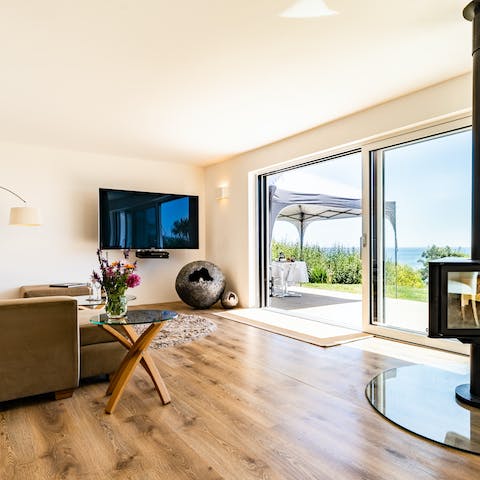 Get cosy in the stylish living room, with the warmth of the log burner and the sound of the waves outside 
