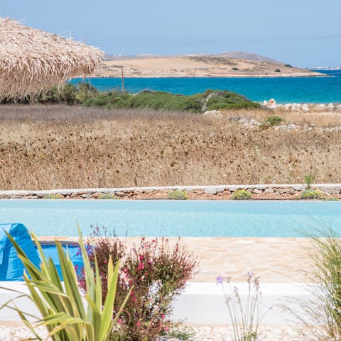Catch a few rays by the pool, gazing out over the glittering waters of the Aegean
