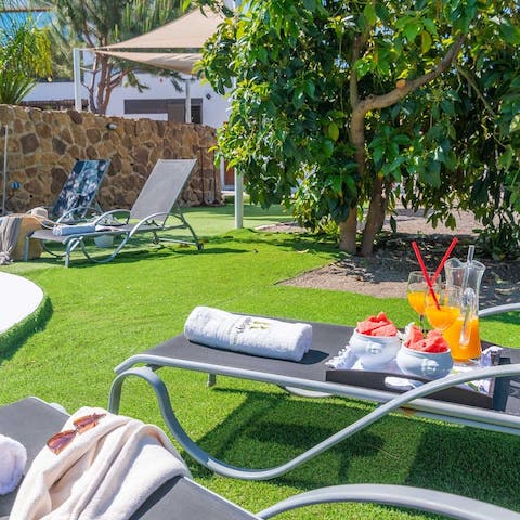 Lounge on the sun beds by the pool with a book and a cocktail