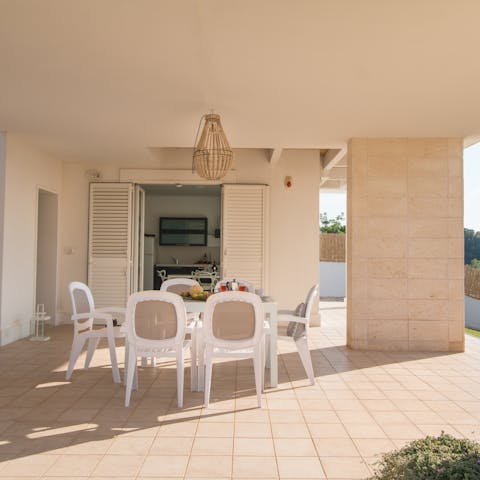 Dine in the shade of the veranda after cooking in the outdoor kitchen
