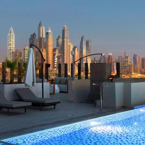 Admire the sparkling city view from the building's rooftop swimming pool