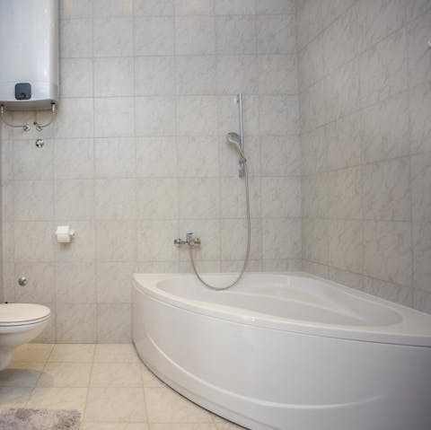 Treat yourself to a rejuvenating soak in the corner bathtub