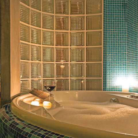 Pour a glass of wine and relax in the luxurious master bathtub at the end of a busy day