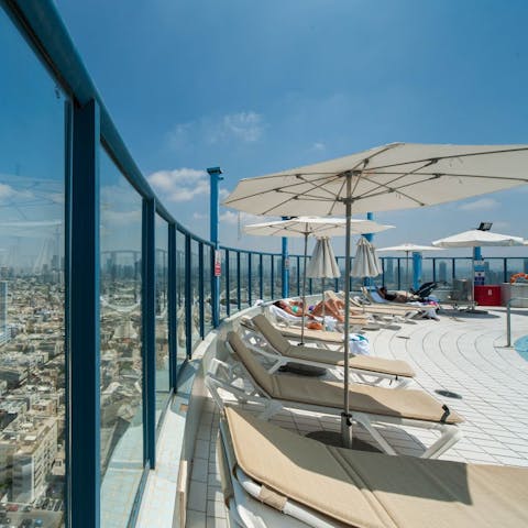 Take in the sun on the beds with an incredible view of the city