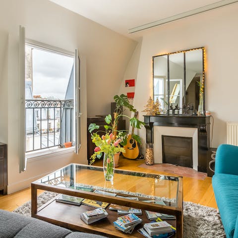 Get cosy in the charming living room, with views of the Parisian rooftops outside your window 