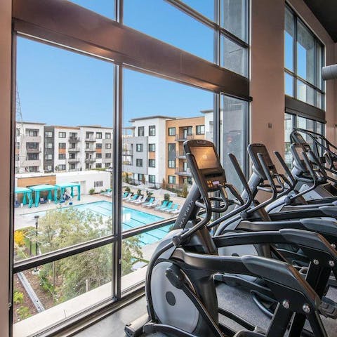 Stay on top of your fitness routine with a poolside view at the gym