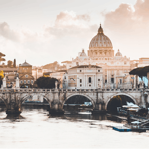 Catch the sunset over St Peter's Basilica from the Ponte Sant’Angelo—a five minute walk from your home