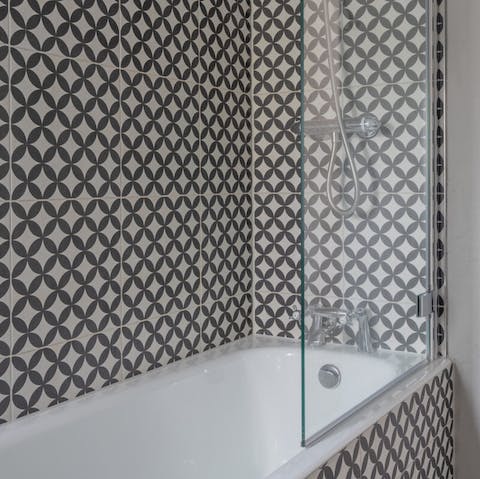 Treat yourself to a leisurely soak in the eye-catchingly tiled bathtub