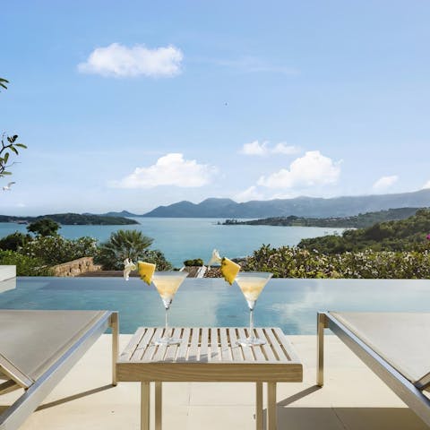 Sip on Mai Tais as you lounge by the infinity pool overlooking the sea