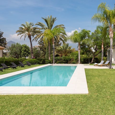 Show off your backstroke underneath palm trees in the villa's swimming pool
