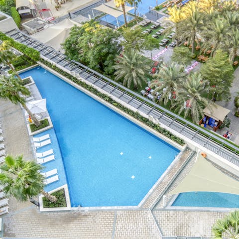 Enjoy a refreshing dip in the communal pool surrounded by palm trees