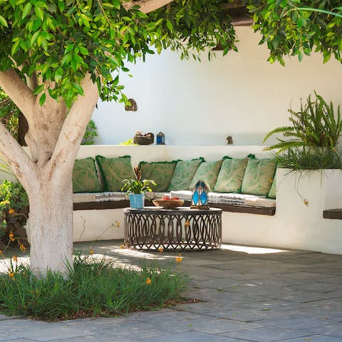 Sit back on the outdoor sofa and watch the palm trees sway in the tropical garden
