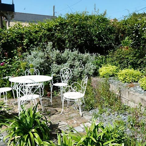 Make the most of the sunshine in your private, enclosed garden surrounded by shrubs and flowers