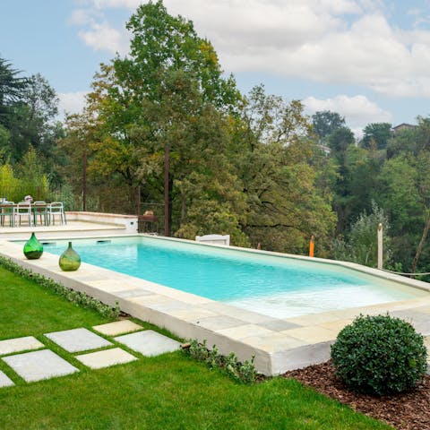 Swim laps in the pool while gazing out into the forest