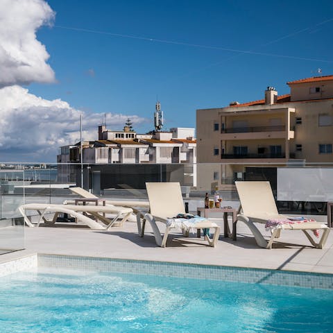 Relax by the rooftop pool with a glass of red