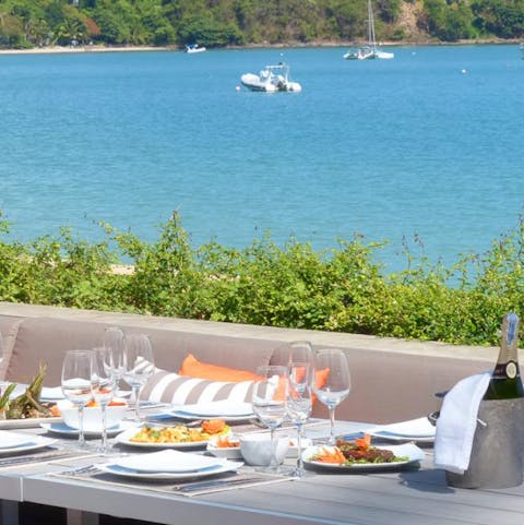 Watch the boats skirt across the impossibly blue sea from the outdoor dining table