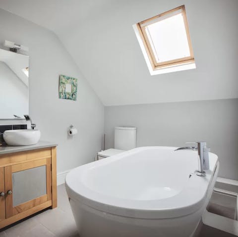 Lie back and soak in the bathtub under the skylight