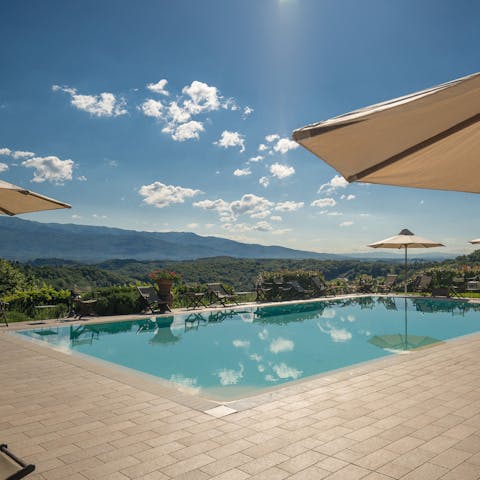 Look out over rolling Tuscan hills from the shared swimming pool