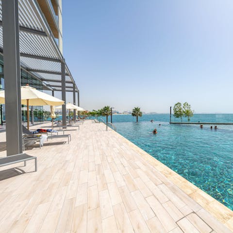 Catch some rays by the stunning infinity pool with Dubai skyline views