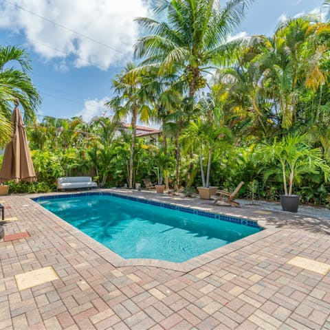 Dip into the private swimming pool, surrounded by vibrant green palm trees