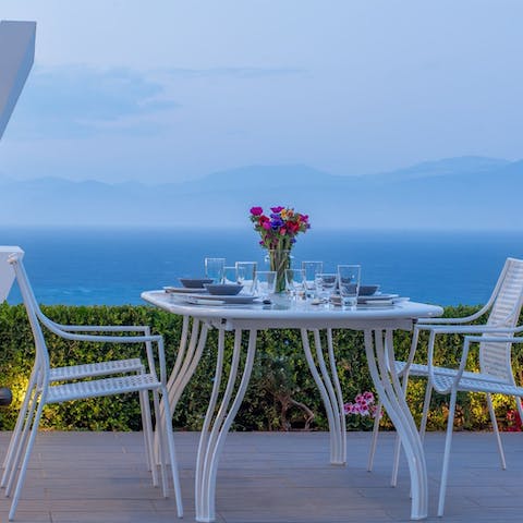 Dine on the terrace as the sun sets over the misty mountains beyond the sea