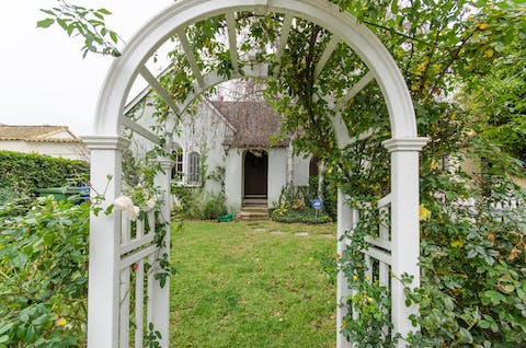 Peak at the pretty home through the rose arch 