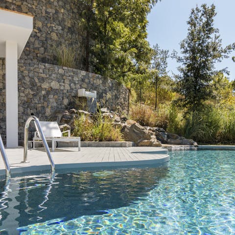 Glide gracefully through the villa's swimming pool and retire to a lounger after a dip