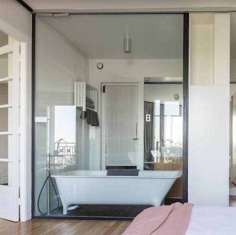 The glass wall between the bathroom and bedroom