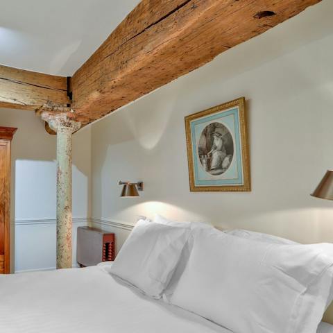 Admire the rustic charm of the exposed beams in the bedroom