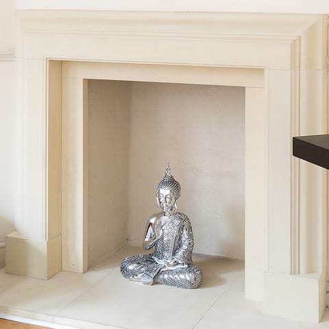 A silver buddha in the fireplace