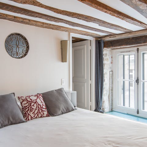 Sleep sound beneath rustic wooden beams showing off the building's history