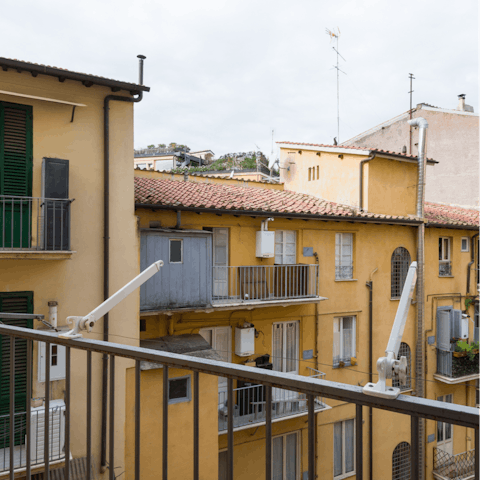 Step out onto the balcony and watch the world — or the building's courtyard, at least — go by