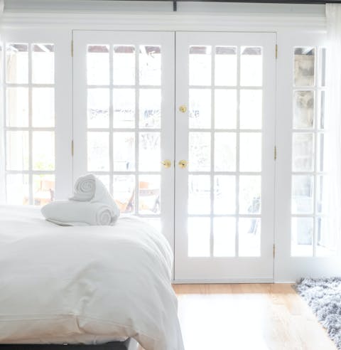 Rise and shine in the bright bedroom with large french doors