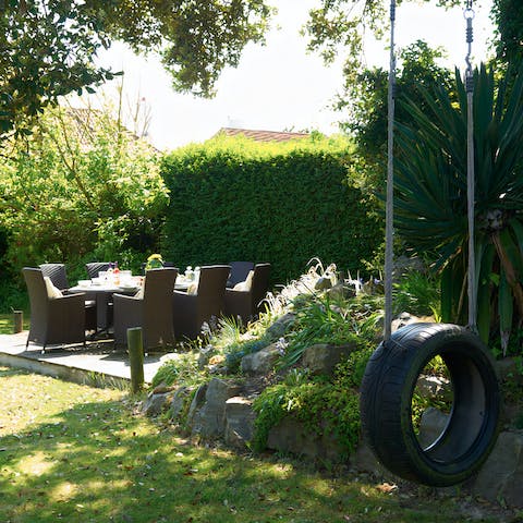 Enjoy sundowners in the garden as little ones play on the tyre swing 