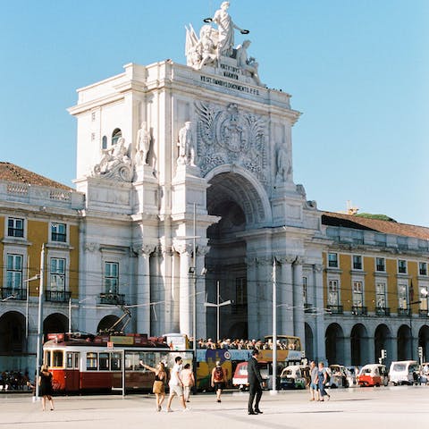 Stroll around the grand Praça do Comércio in the glorious sunshine