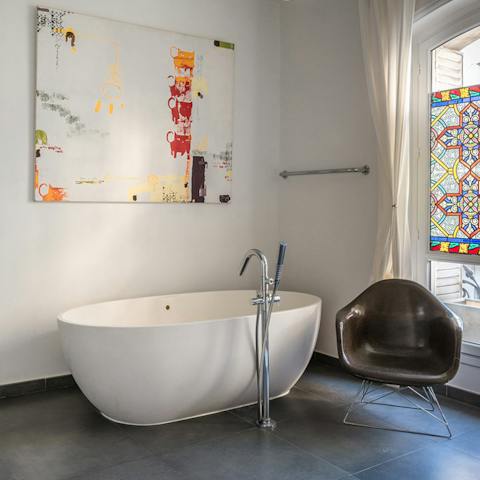 Take a relaxing bath with a view of beautiful stained glass