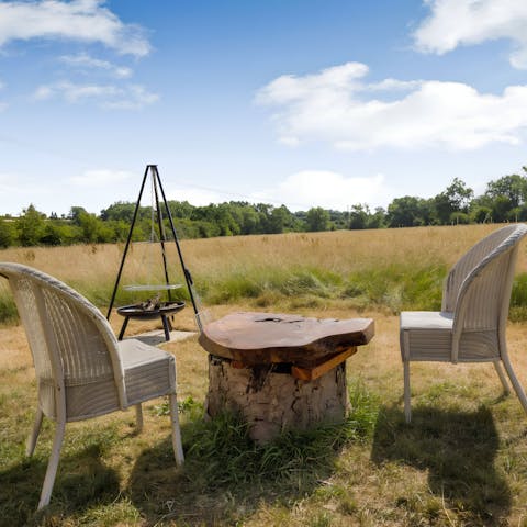 Chat beside the fire pit amid a peaceful meadow setting